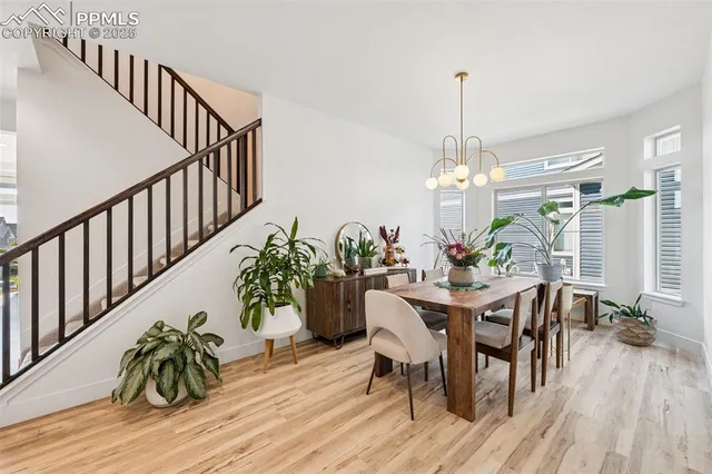 a dining room filled chandelier and wooden floor