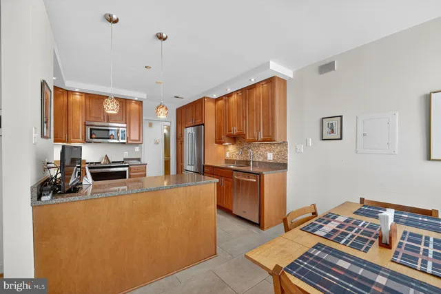 a kitchen with stainless steel appliances granite countertop a refrigerator stove top oven and sink