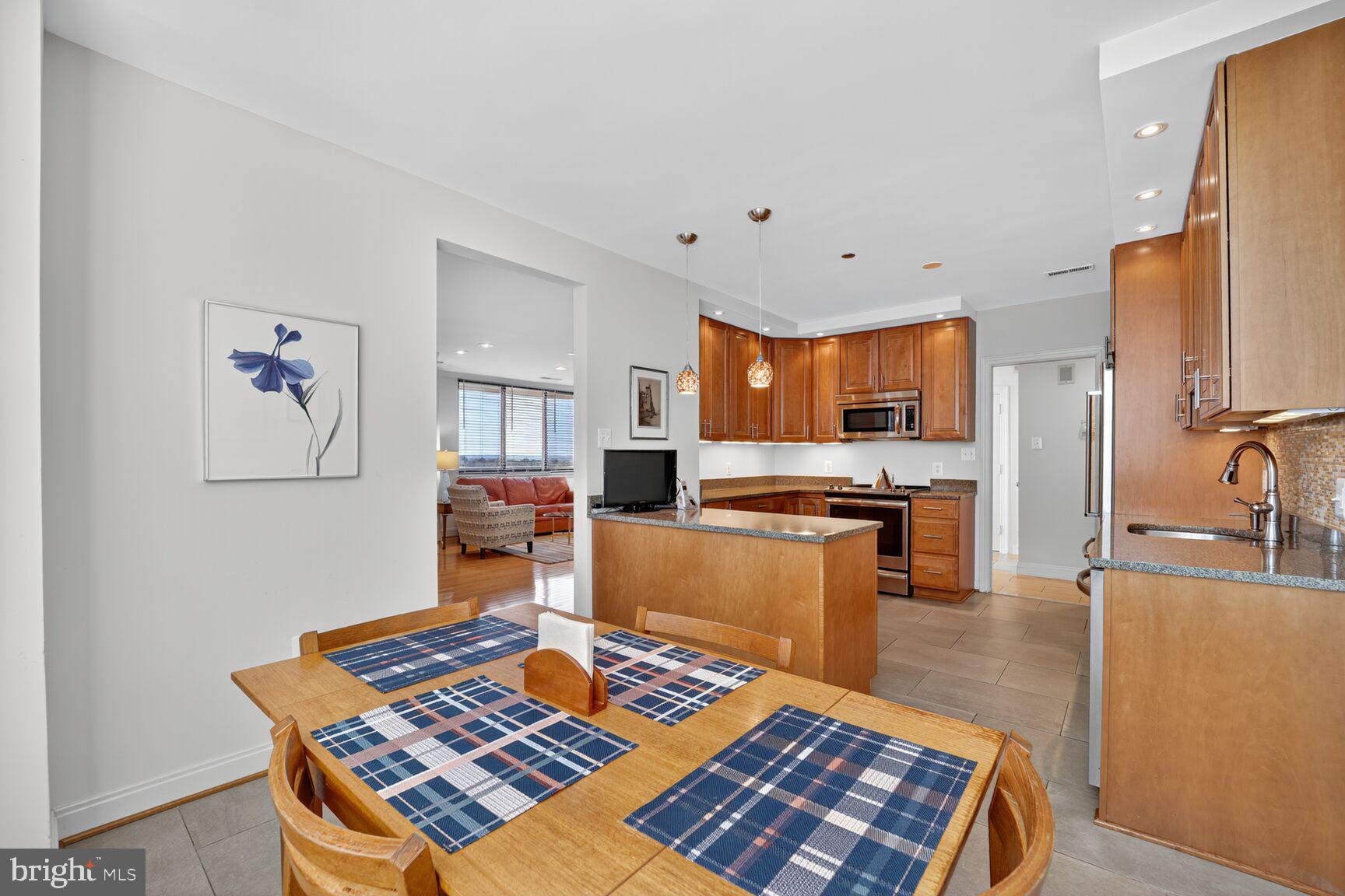 4550 North Park Avenue, Unit 1005 Chevy Chase, MD 20815 - Photo 12 of 30 a living room with stainless steel appliances furniture a rug and a kitchen view