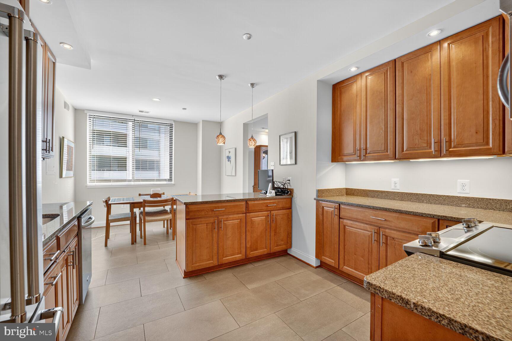 4550 North Park Avenue, Unit 1005 Chevy Chase, MD 20815 - Photo 16 of 30 a kitchen with stainless steel appliances granite countertop sink stove top oven and cabinets