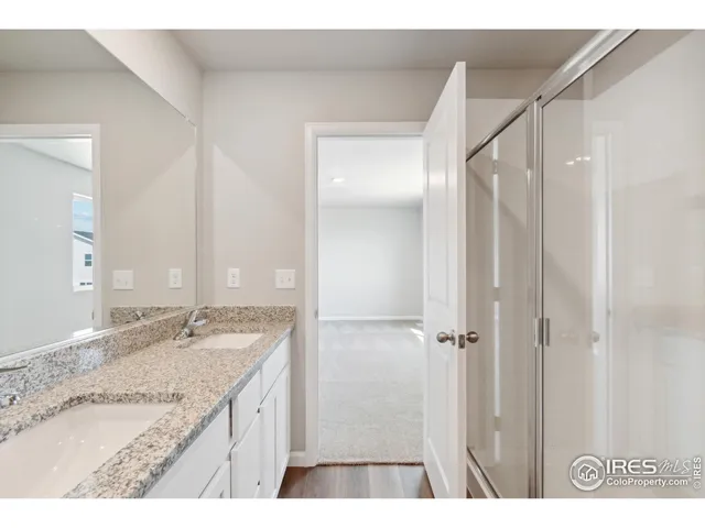 a bathroom with a granite countertop sink a mirror and a shower