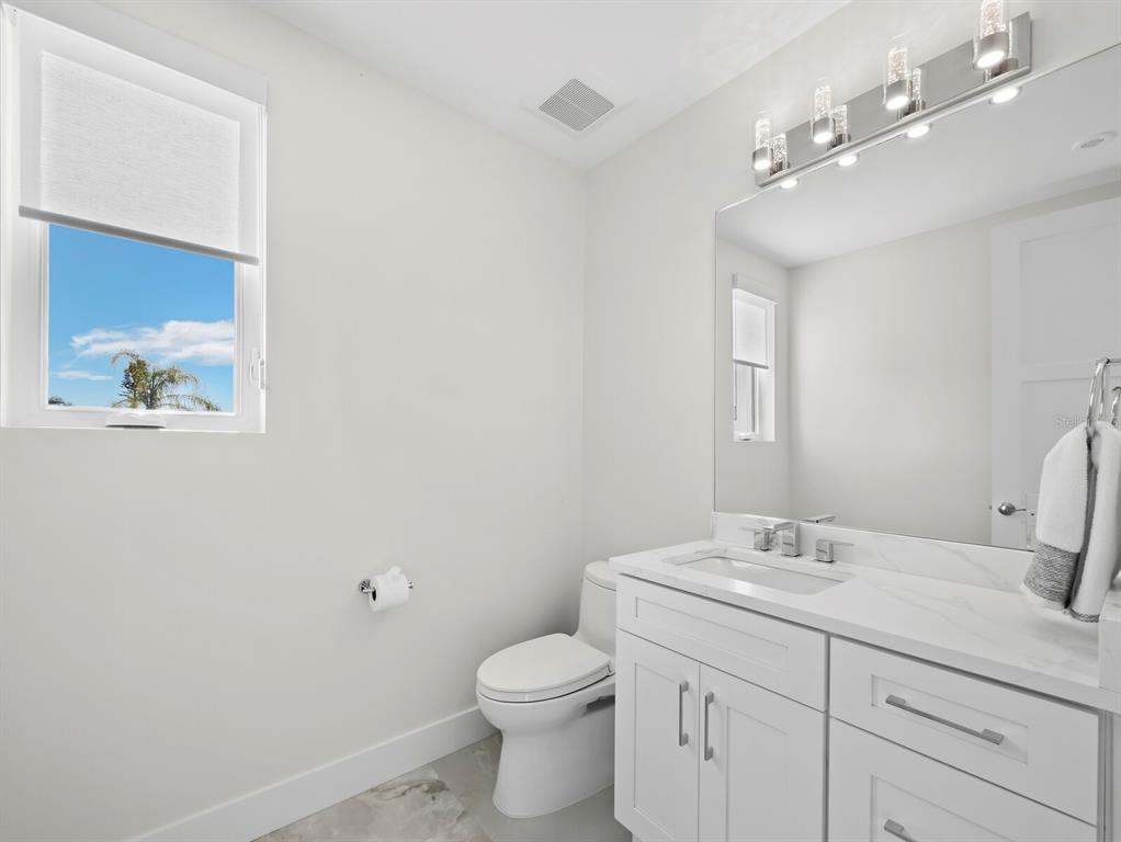 635 Jungle Queen Way Longboat Key, FL 34228 - Photo 22 of 55 a bathroom with a toilet sink and mirror