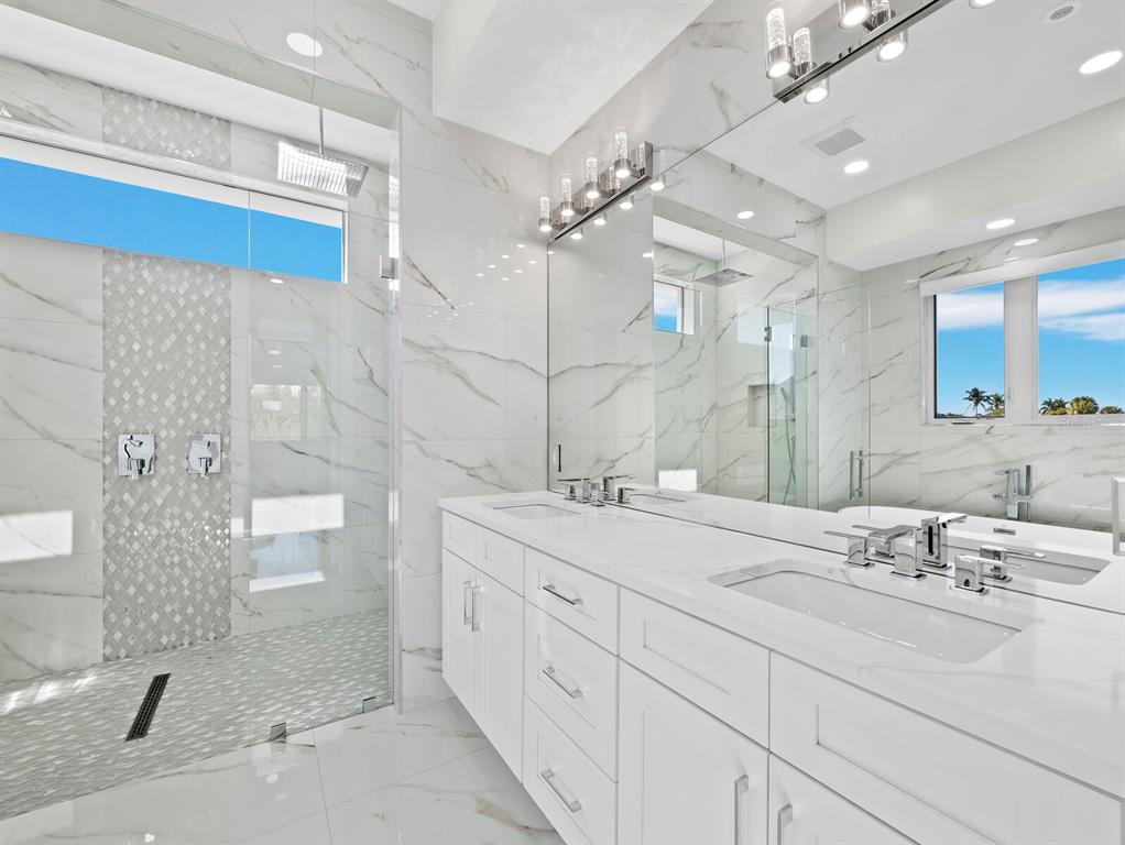635 Jungle Queen Way Longboat Key, FL 34228 - Photo 25 of 55 a bathroom with a double vanity sink mirror and shower