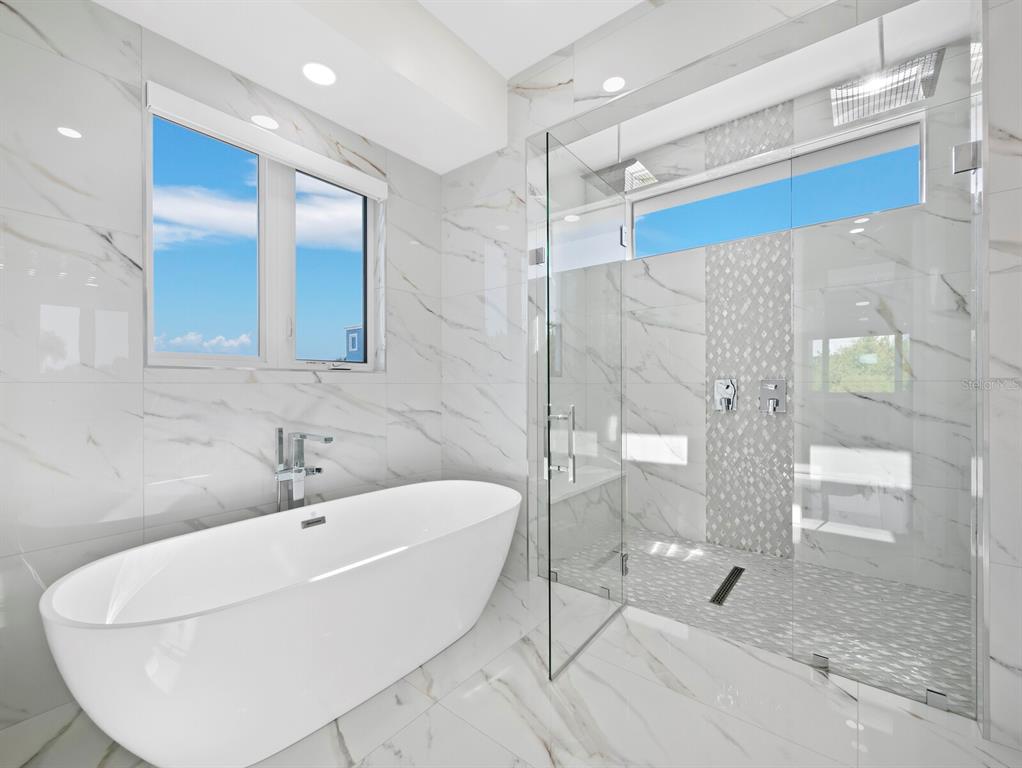 635 Jungle Queen Way Longboat Key, FL 34228 - Photo 26 of 55 a bathroom with a bathtub and a shower
