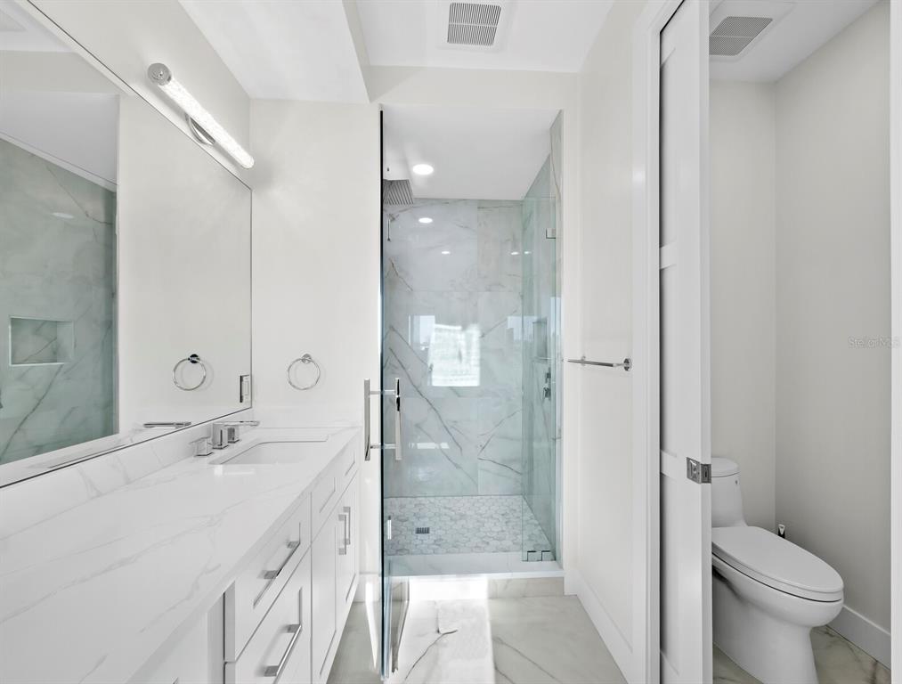 635 Jungle Queen Way Longboat Key, FL 34228 - Photo 40 of 55 a bathroom with a double vanity sink toilet and shower