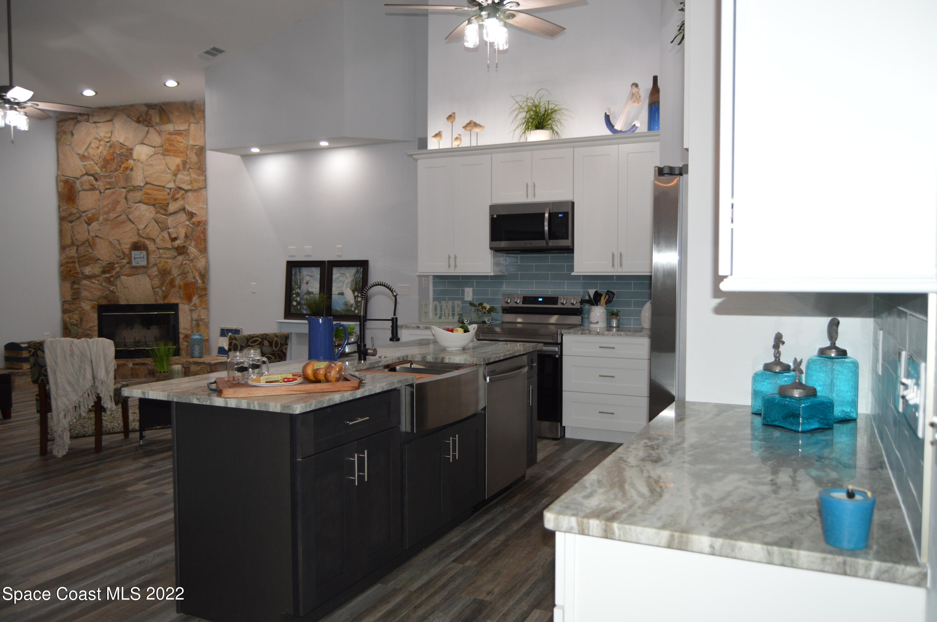 3460 Carter Road Mims, FL 32754 - Photo 6 of 32 a kitchen with stainless steel appliances granite countertop a sink dishwasher stove and microwave with wooden floor