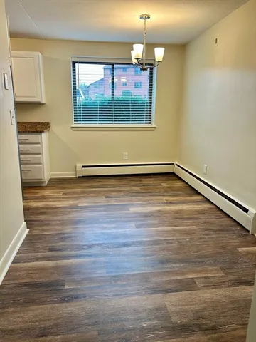 a view of a room with wooden floor and chandelier