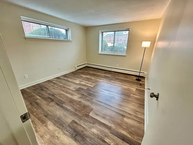 a view of empty room with wooden floor
