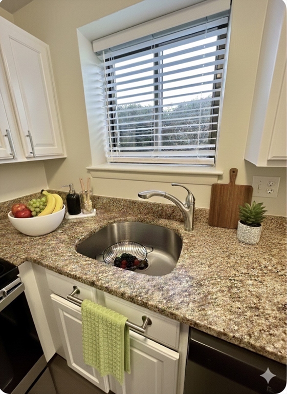 70 C Charles River Road, Unit 70C Waltham, MA 02453 - Photo 6 of 27 a kitchen with a granite countertop sink stove and cabinets