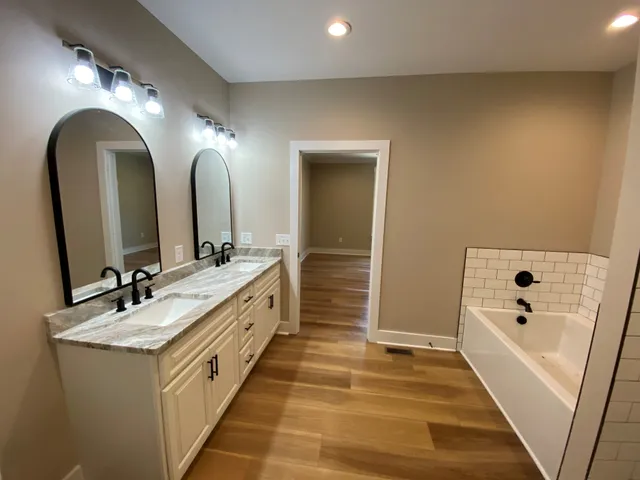 a bathroom with a granite countertop sink a mirror and shower