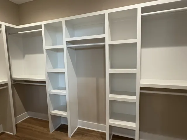 a large kitchen with stainless steel appliances kitchen island wooden floors and living room view