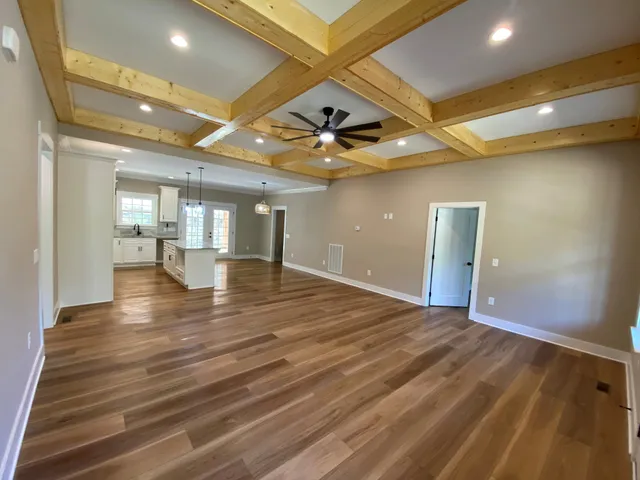 a kitchen with stainless steel appliances granite countertop a sink a stove a refrigerator and island with wooden floor