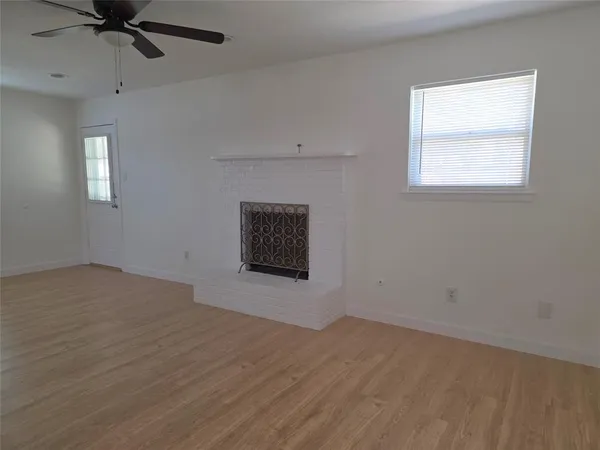 an empty room with a window and a ceiling fan