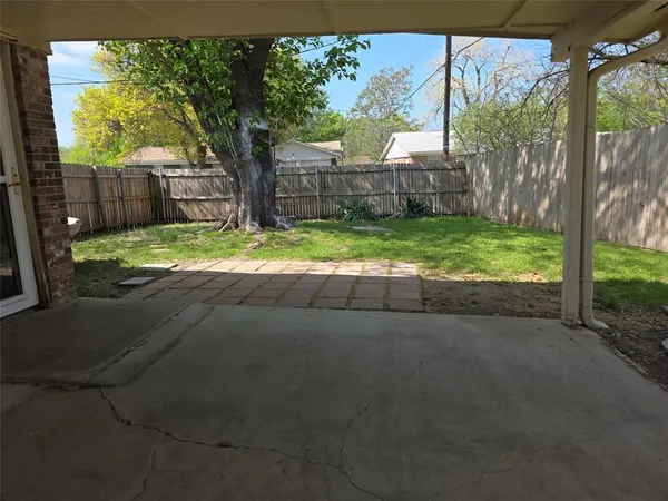 a backyard of a house with barbeque oven table and chairs