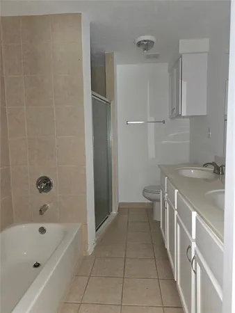 a bathroom with a granite countertop sink a toilet and bathtub