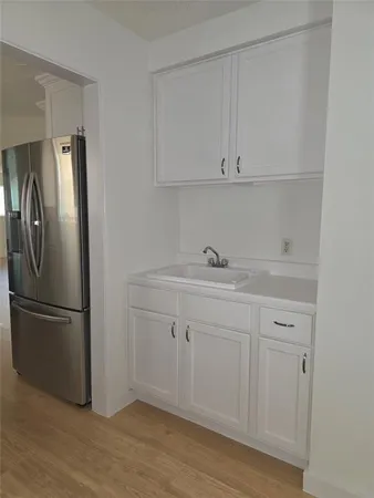 a kitchen with stainless steel appliances granite countertop a refrigerator sink and white cabinets