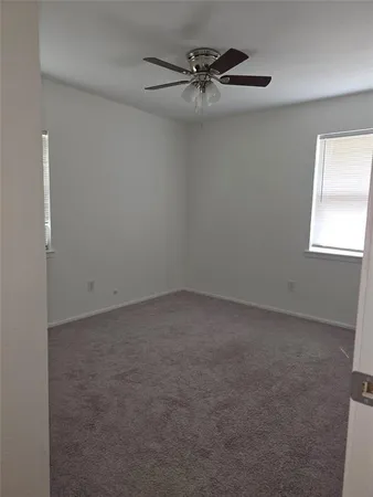 an empty room with a window and a fan