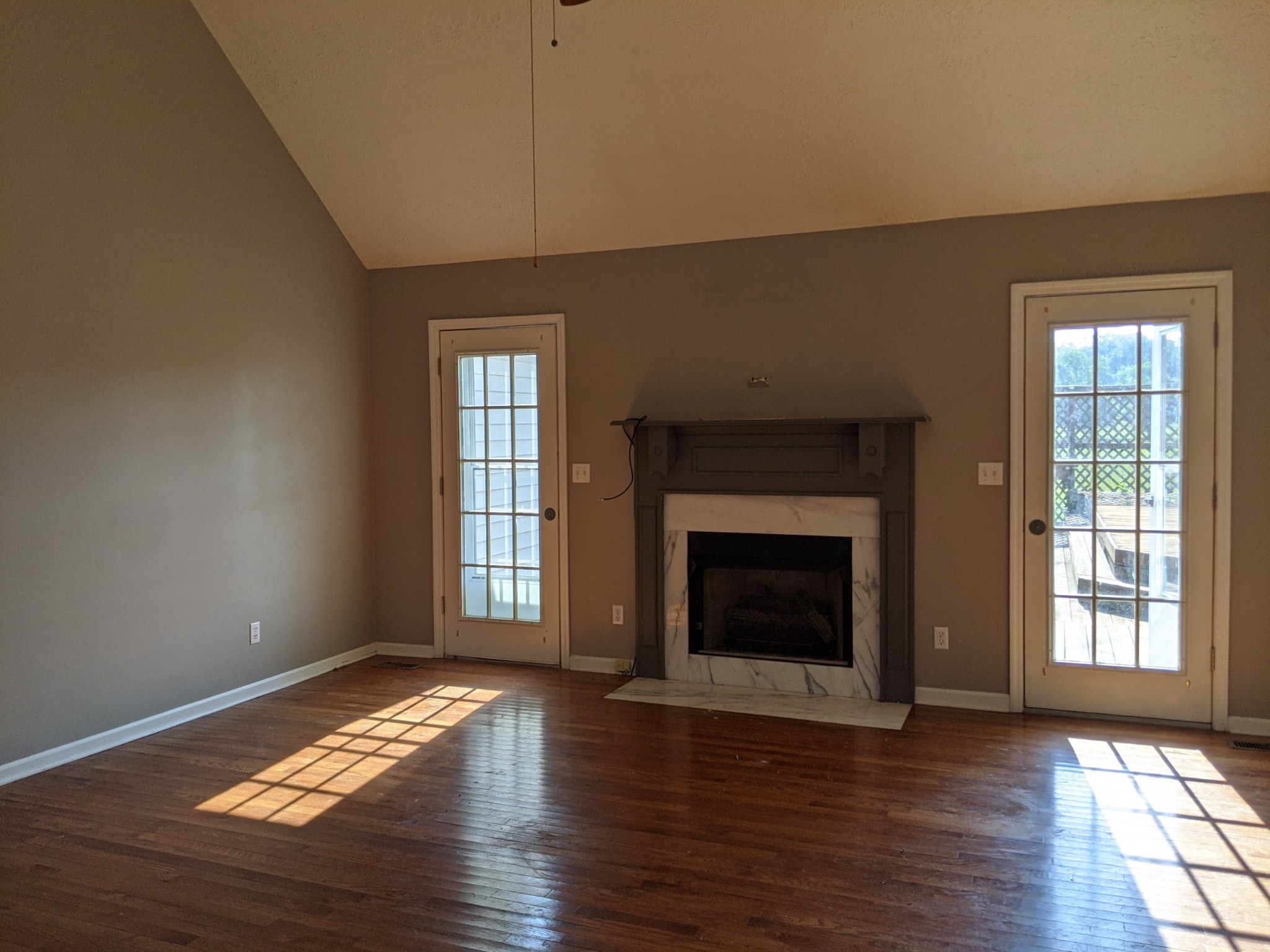 479 Rock Road Morrison, TN 37357 - Photo 2 of 16 a view of an empty room with wooden floor fireplace and a window