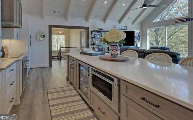 a living room with furniture a flat screen tv and a large window