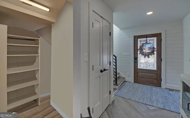a living room with furniture a flat screen tv and a large window