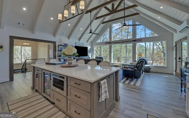 a living room with furniture a flat screen tv and a floor to ceiling window
