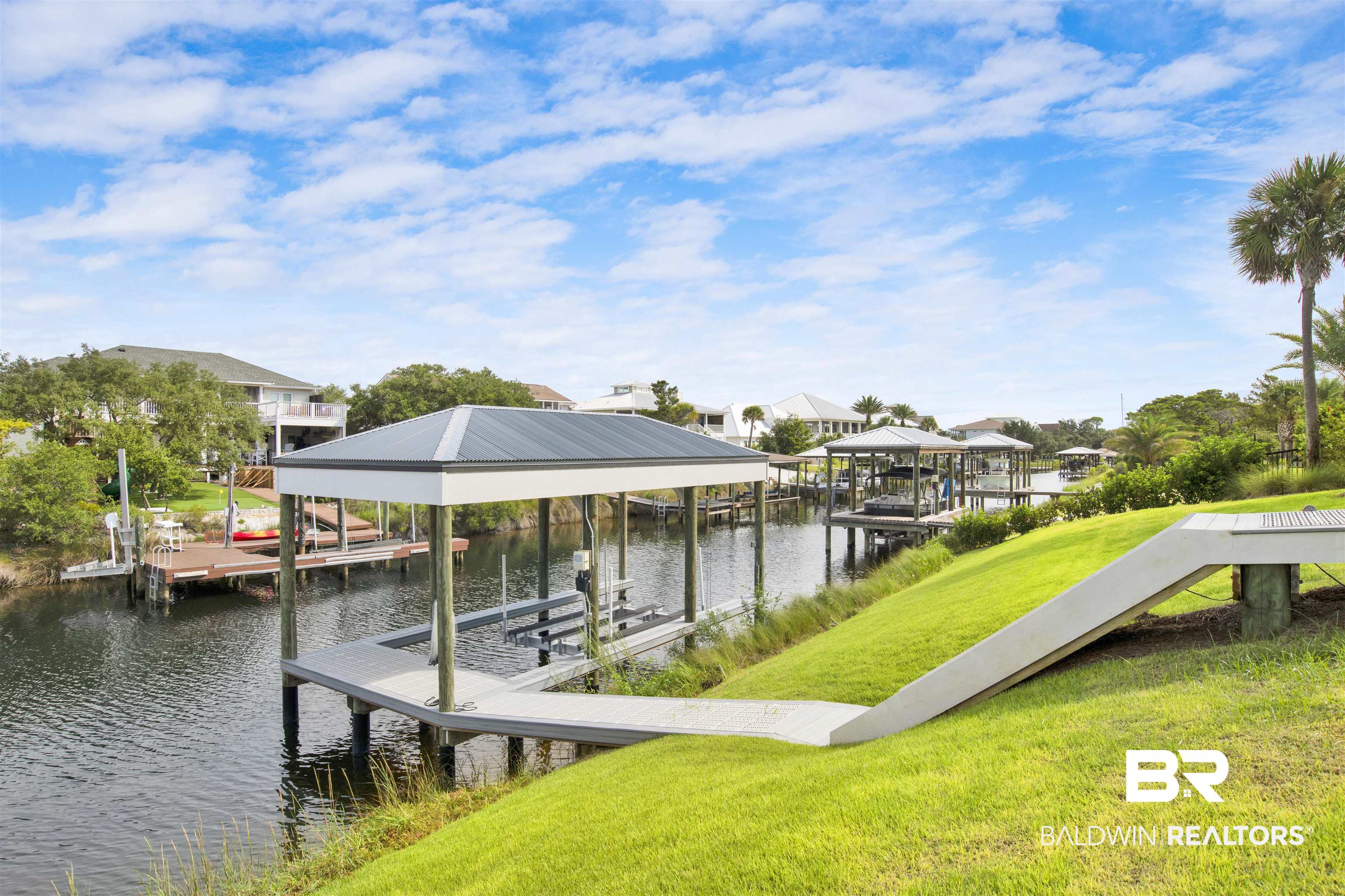 30239 Canal Court Orange Beach, AL 36561 - Photo 66 of 70 Dock with boat lift, a yard, and a water view