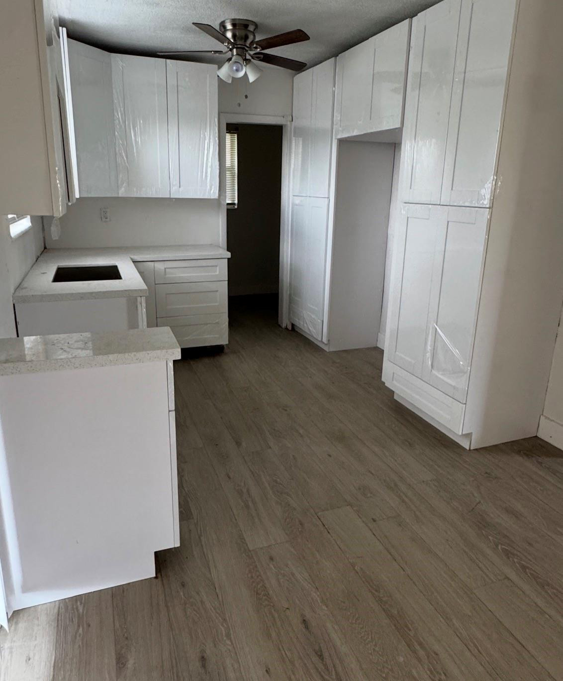 6201 Southwest 19th Street Miramar, FL 33023 - Photo 7 of 8 an empty room with wooden floor cabinet and windows