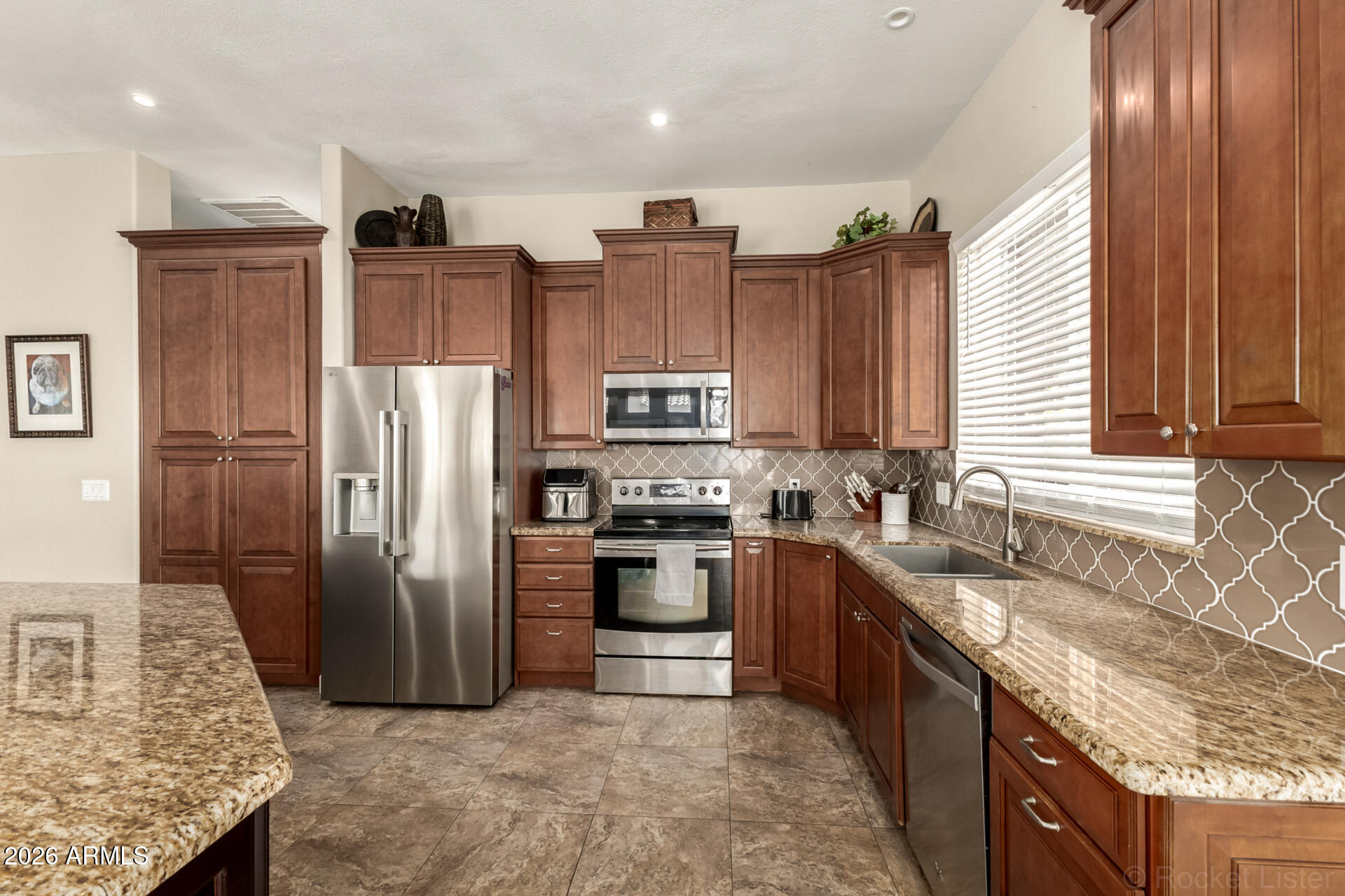 9545 East Inverness Circle Mesa, AZ 85209 - Photo 9 of 26 a kitchen with stainless steel appliances granite countertop a refrigerator a stove and a sink