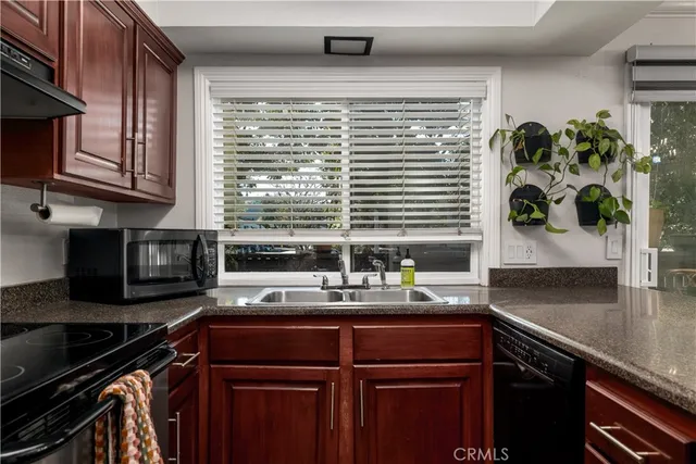 a kitchen with a sink a counter appliances and cabinets