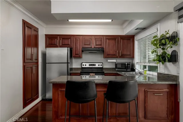 a kitchen with kitchen island granite countertop wooden cabinets and stainless steel appliances