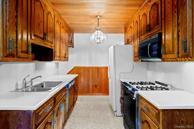 a kitchen with stainless steel appliances granite countertop a sink a stove and a wooden floors