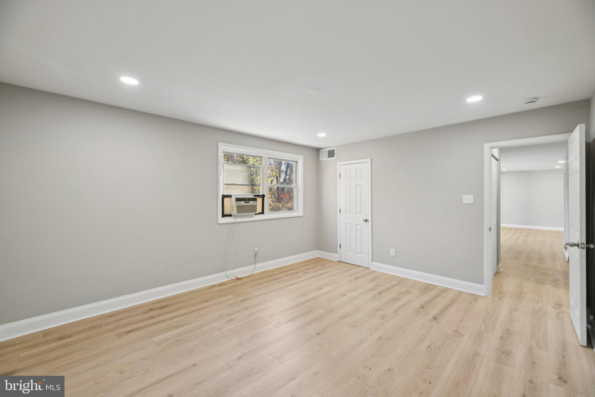 3138 Brinkley Road, Unit 8102 Temple Hills, MD 20748 - Photo 18 of 27 a view of an empty room with wooden floor and a window
