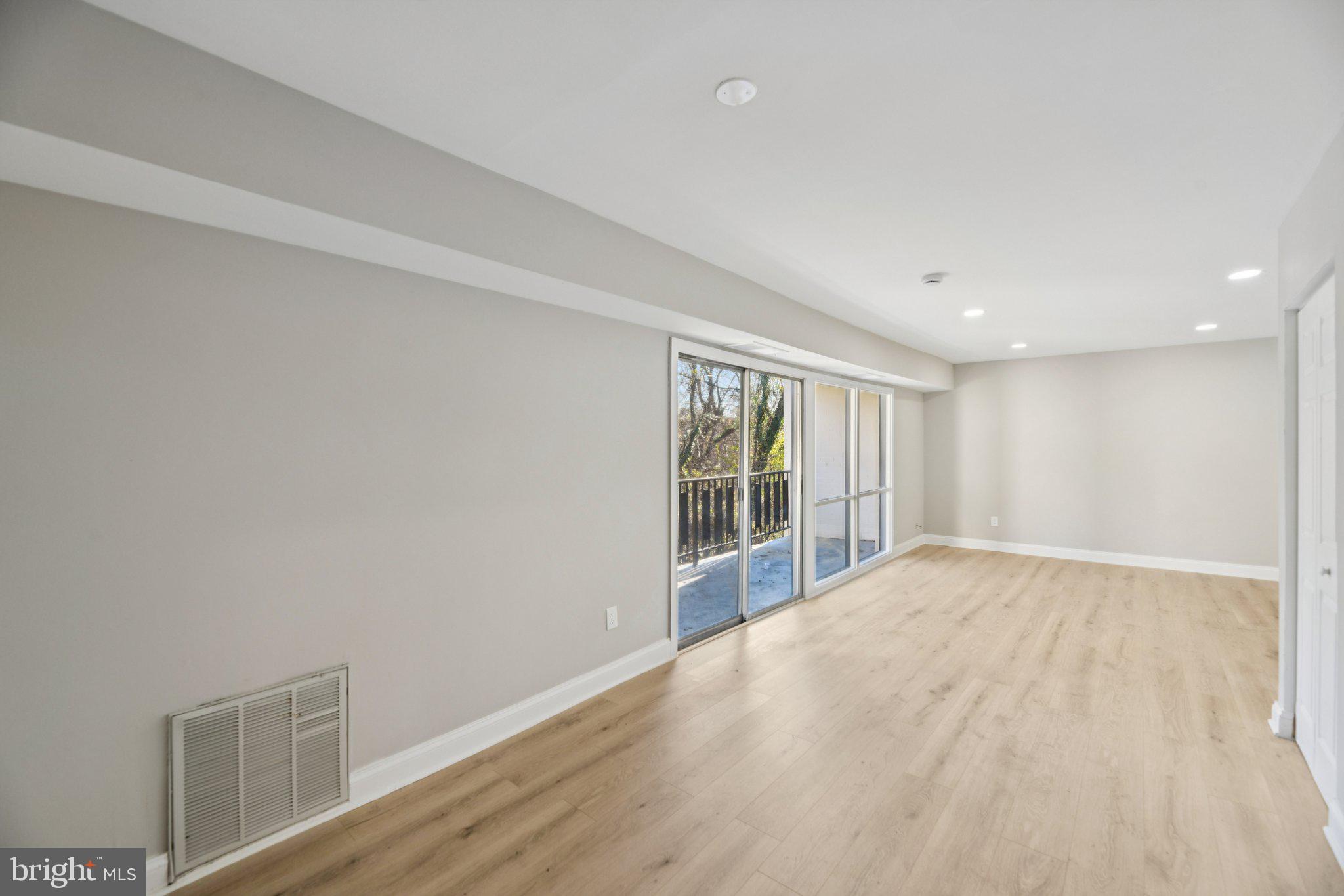 3138 Brinkley Road, Unit 8102 Temple Hills, MD 20748 - Photo 2 of 27 a view of an empty room with wooden floor and a window