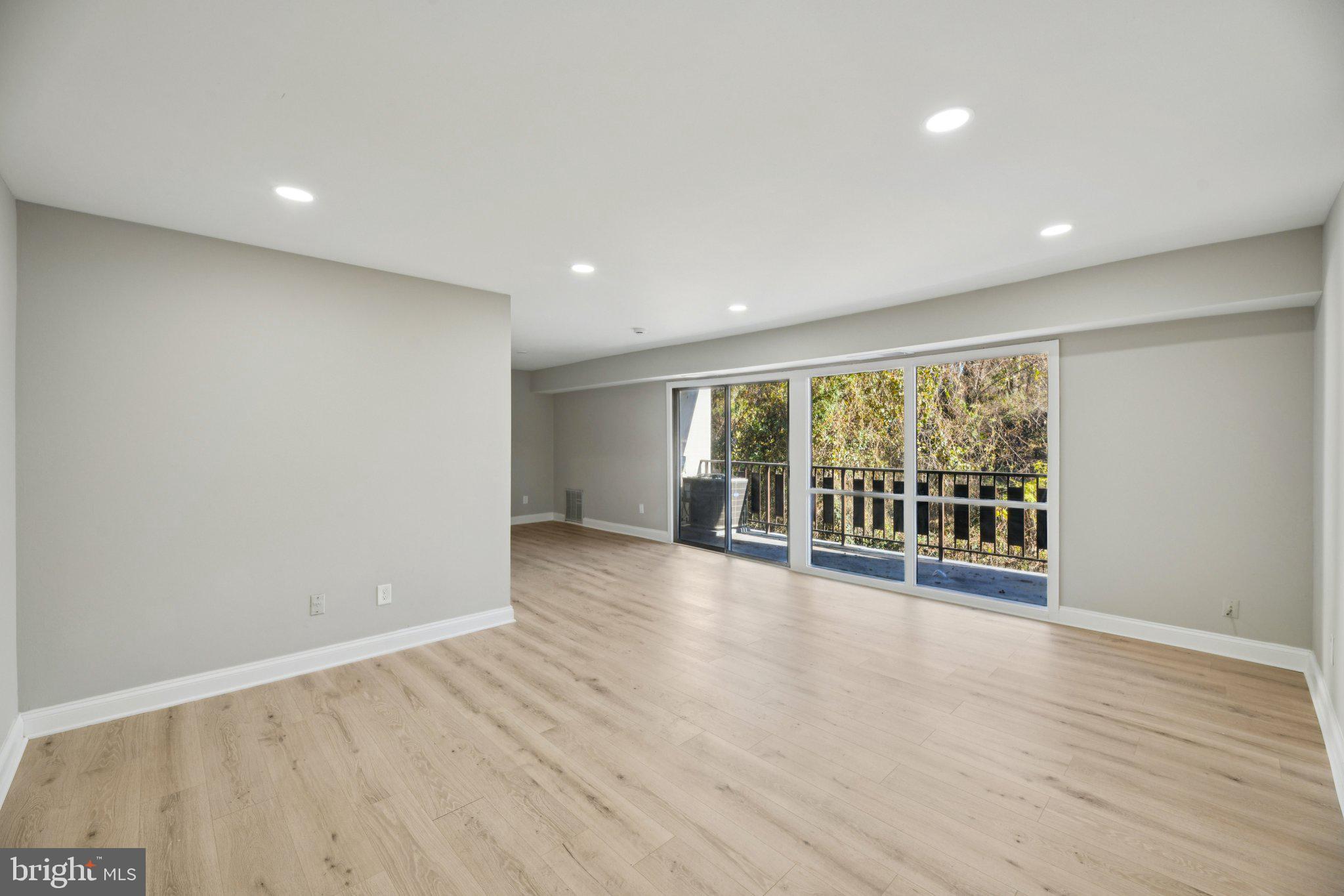 3138 Brinkley Road, Unit 8102 Temple Hills, MD 20748 - Photo 4 of 27 a view of an empty room with wooden floor and a window