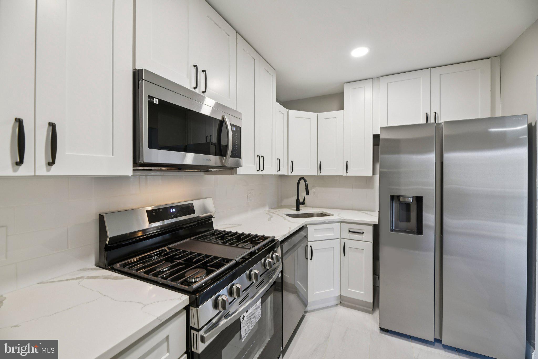 3138 Brinkley Road, Unit 8102 Temple Hills, MD 20748 - Photo 8 of 27 a kitchen with stainless steel appliances white cabinets and a stove top oven