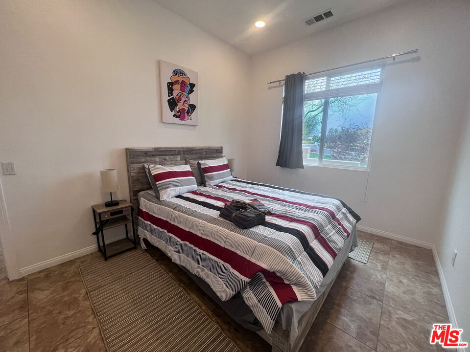 84226 Canzone Drive Indio, CA 92203 - Photo 11 of 23 a bedroom with a bed and a painting on the wall