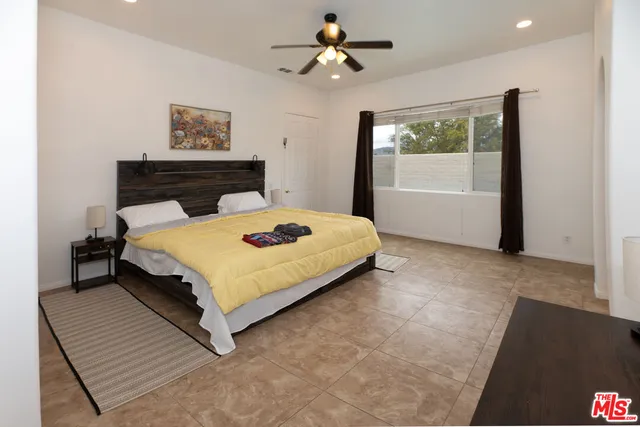 a bedroom with a bed dresser and a window