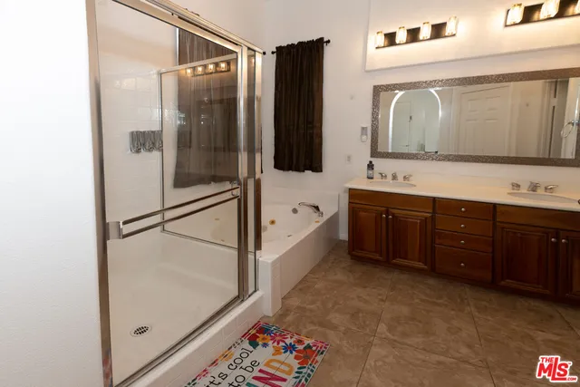 a bathroom with a double vanity sink mirror and shower