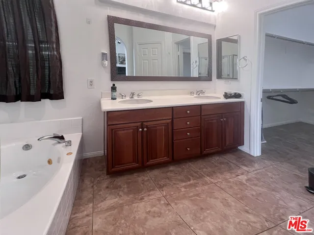 a spacious bathroom with a tub sink and mirror