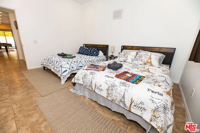 a bedroom with two beds and a lamp