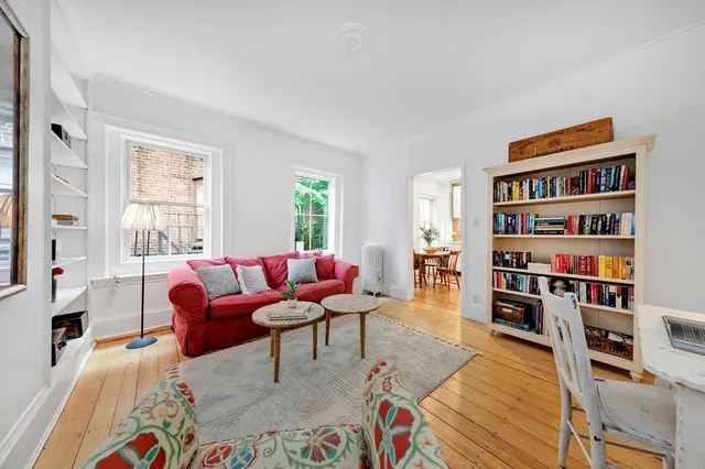 a living room with furniture a rug and a book shelf