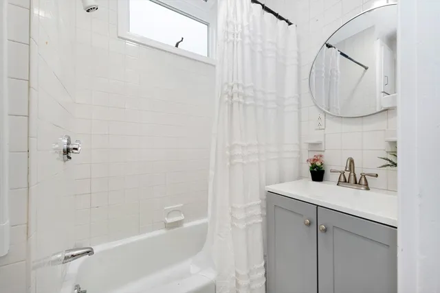 a bathroom with a sink vanity granite tub and shower