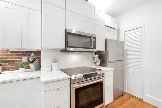 a kitchen with stainless steel appliances a stove microwave and refrigerator
