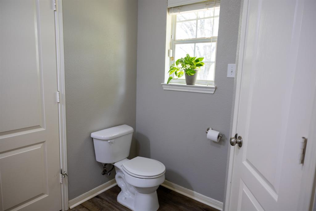 4773 Patton Lake Road Aquilla, TX 76622 - Photo 15 of 25 a white toilet sitting in a bathroom next to a window
