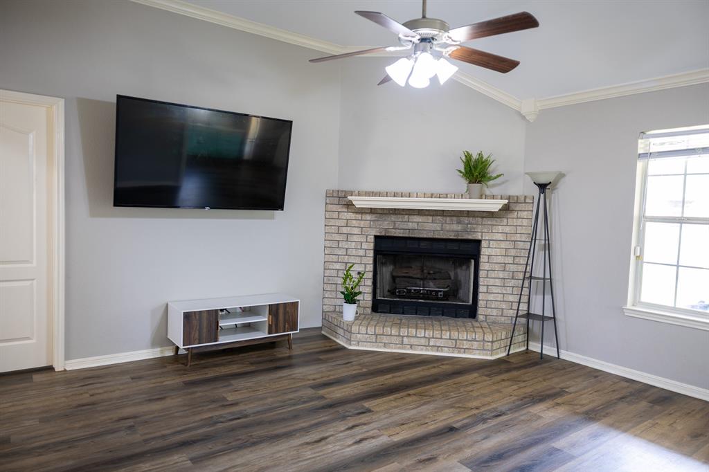 4773 Patton Lake Road Aquilla, TX 76622 - Photo 5 of 25 a living room with a fireplace a flat screen tv and a window