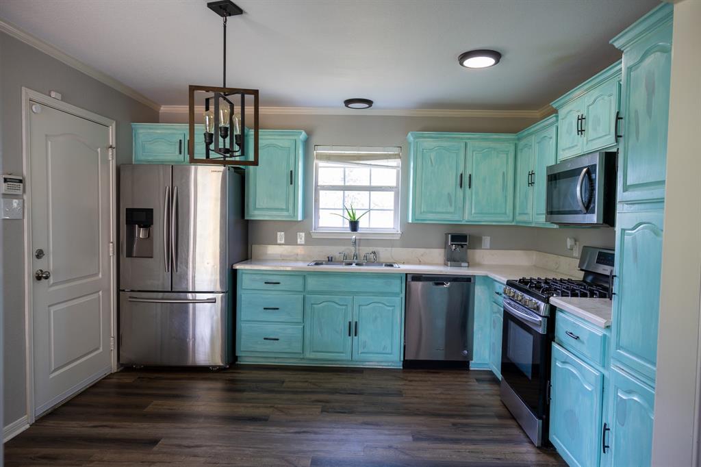 4773 Patton Lake Road Aquilla, TX 76622 - Photo 7 of 25 a kitchen with granite countertop a refrigerator and a stove top oven