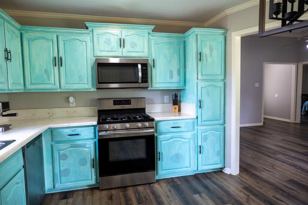 4773 Patton Lake Road Aquilla, TX 76622 - Photo 8 of 25 a kitchen with stainless steel appliances wooden cabinets and a stove top oven