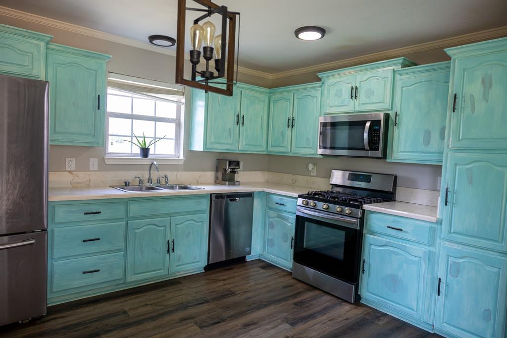 4773 Patton Lake Road Aquilla, TX 76622 - Photo 9 of 25 a kitchen with granite countertop a sink stainless steel appliances and cabinets