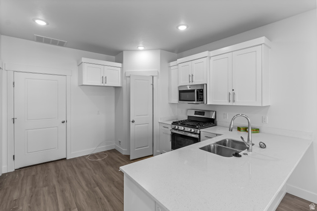 2995 South 265th Street West, Unit 752 Logan, UT 84321 - Photo 5 of 21 Kitchen featuring white shaker-style cabinetry, stainless steel appliances, a double basin sink, light-toned countertops, and wood-finish flooring