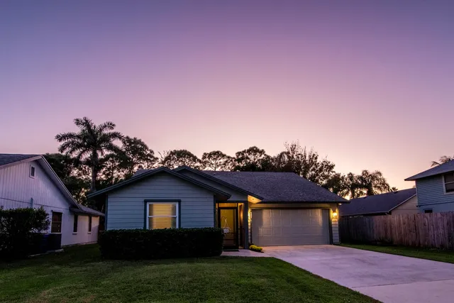 a front view of a house with a garden and yard